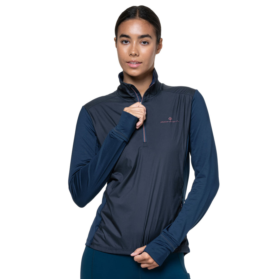 Front view of a model wearing the Ronhill Women's Tech Wind-Block 1/2 Zip in the Dark Navy/Dusty Tulip colourway. (8742677414050)