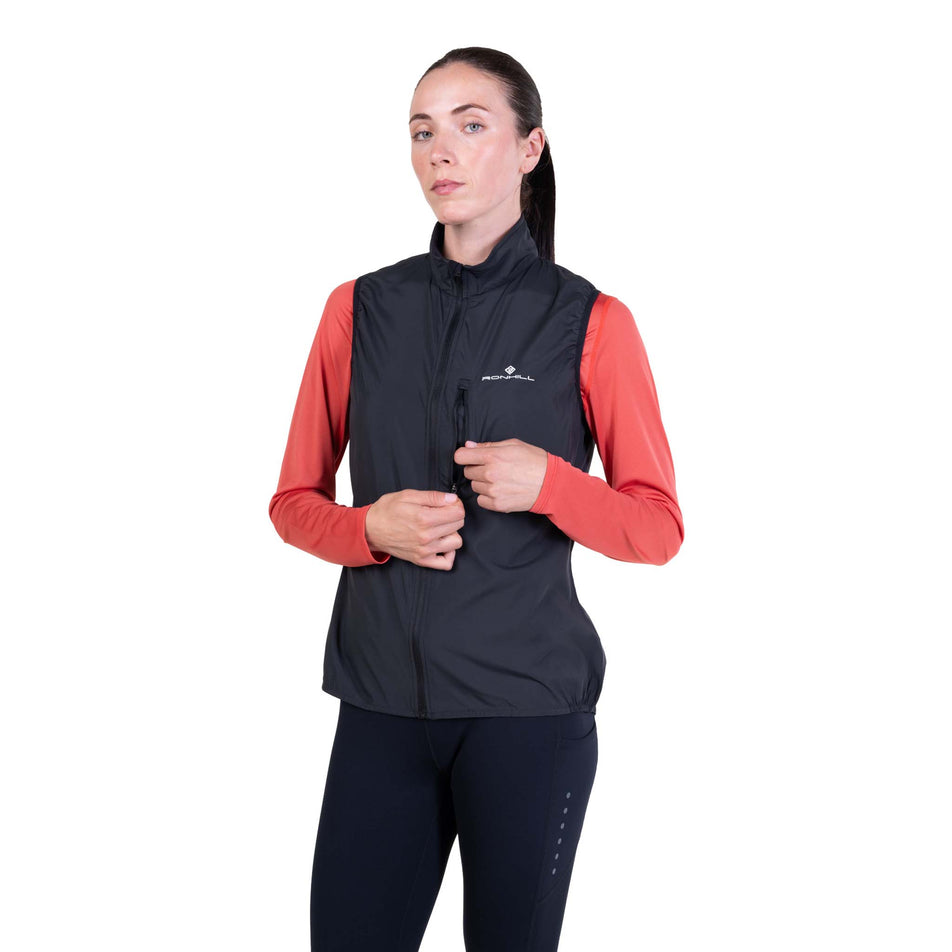 Front view of a model wearing the Ronhill Women's Core Gilet in the Black/Bright White colourway.