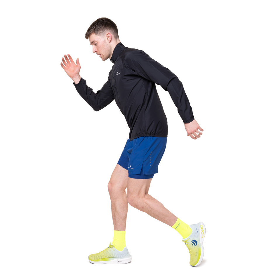 Angled view of a model wearing the Ronhill Men's Core Jacket in the Black/Bright White colourway.