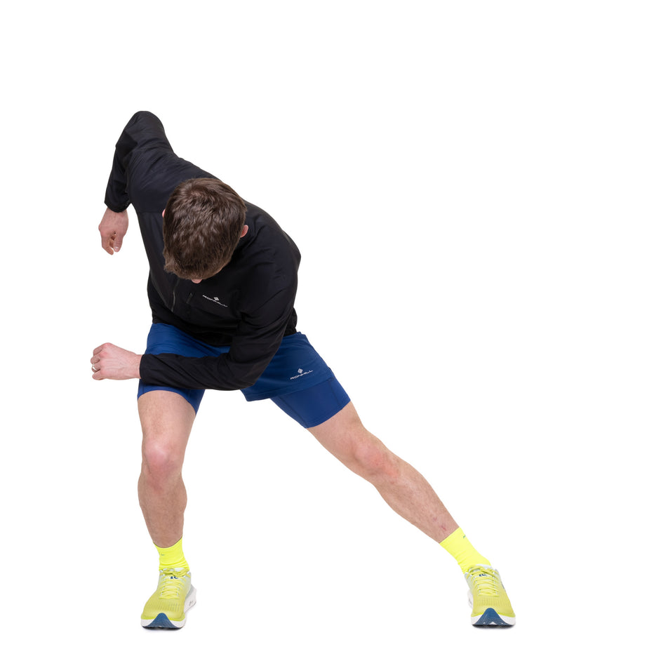 Angled view of a model wearing the Ronhill Men's Core Jacket in the Black/Bright White colourway.