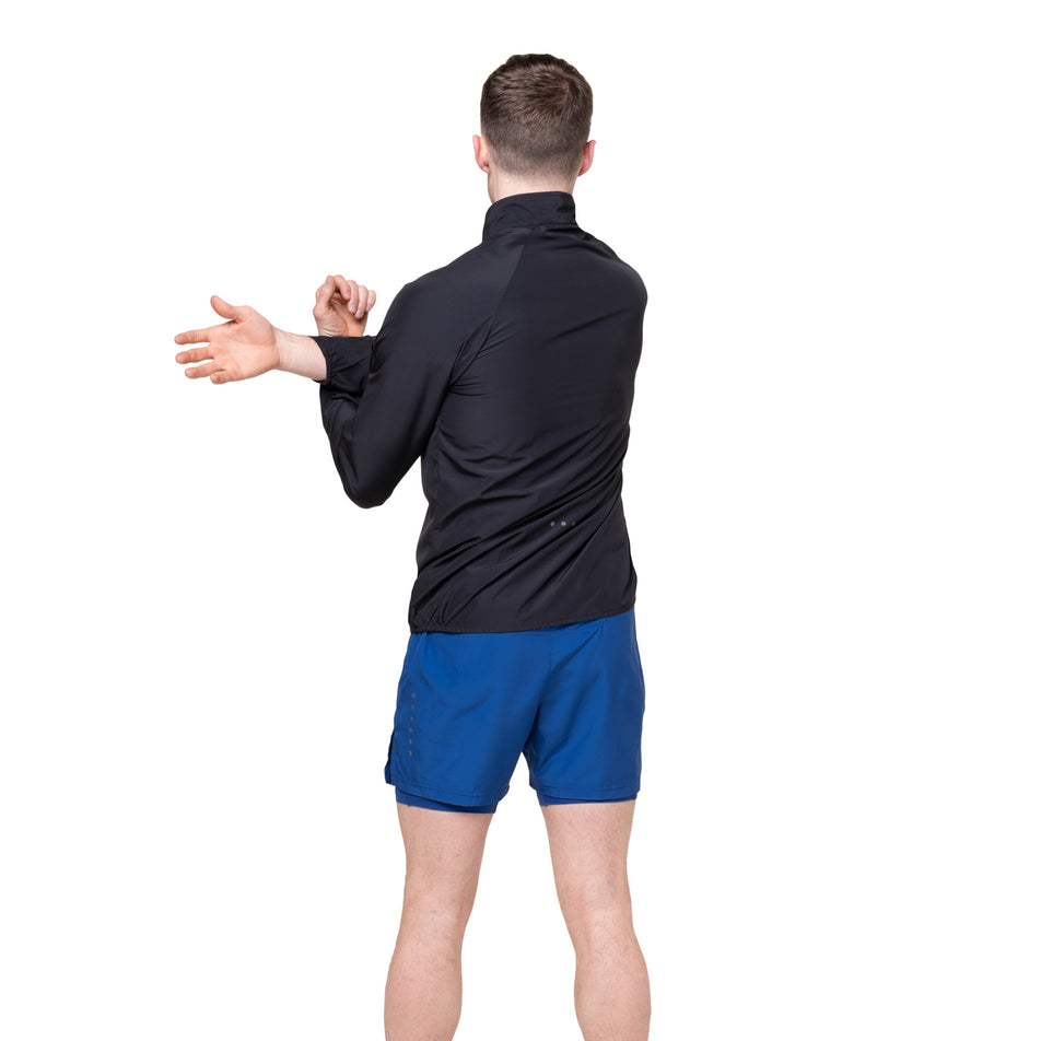 Back view of a model wearing the Ronhill Men's Core Jacket in the Black/Bright White colourway.
