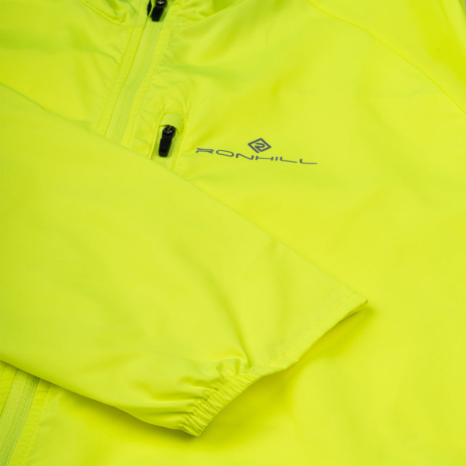 Close-up view of the front of the Ronhill Men's Core Jacket in the Fluo Zest colourway.