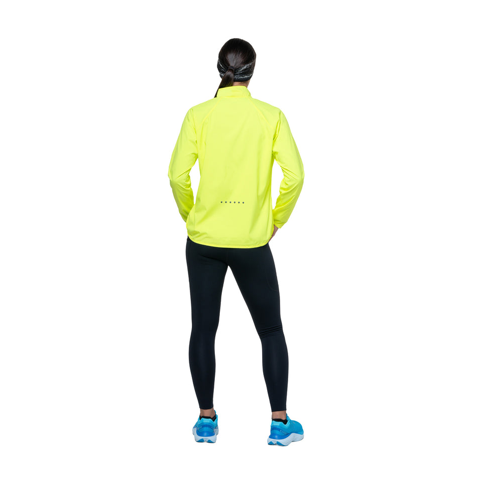Back view of a model wearing the Ronhill Women's Core Jacket in the Fluo Yellow/Black colourway. (8742755369122)