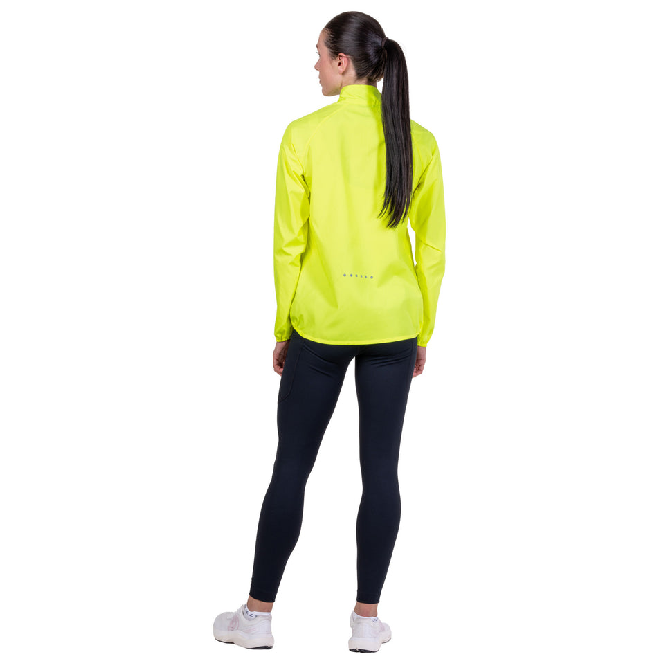 Back view of a model wearing the Ronhill Women's Core Jacket in the Fluo Zest colourway.