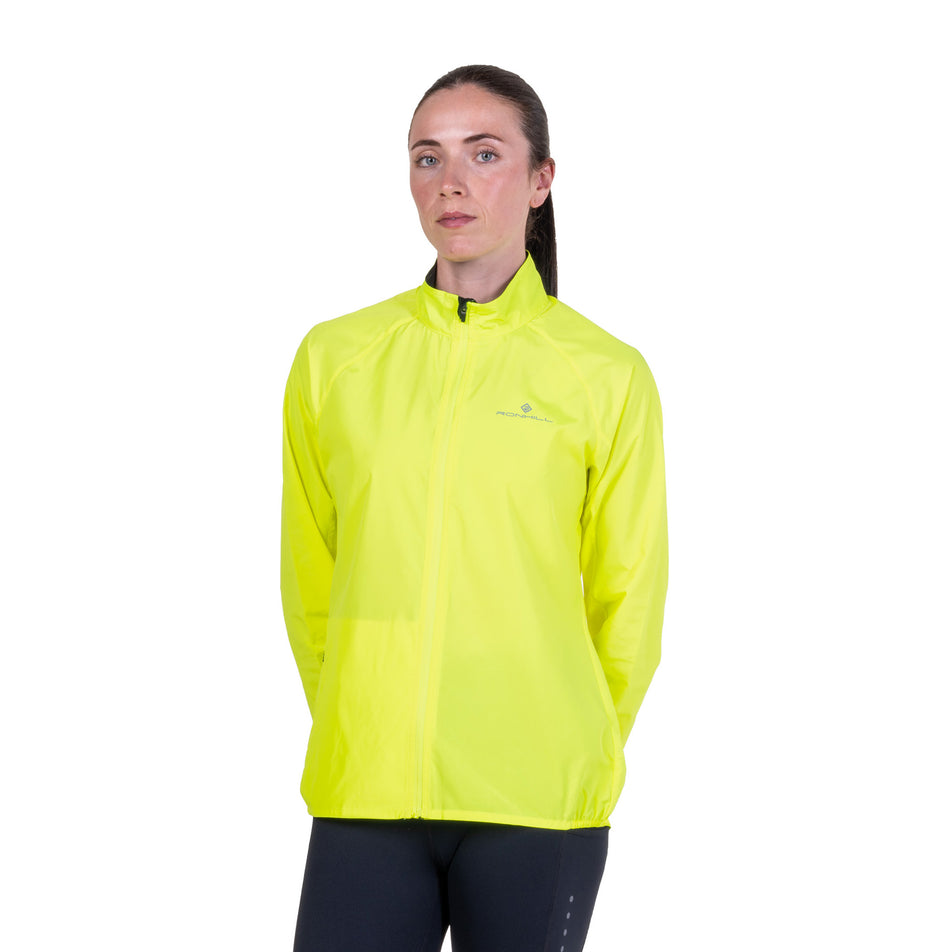 Front view of a model wearing the Ronhill Women's Core Jacket in the Fluo Zest colourway.