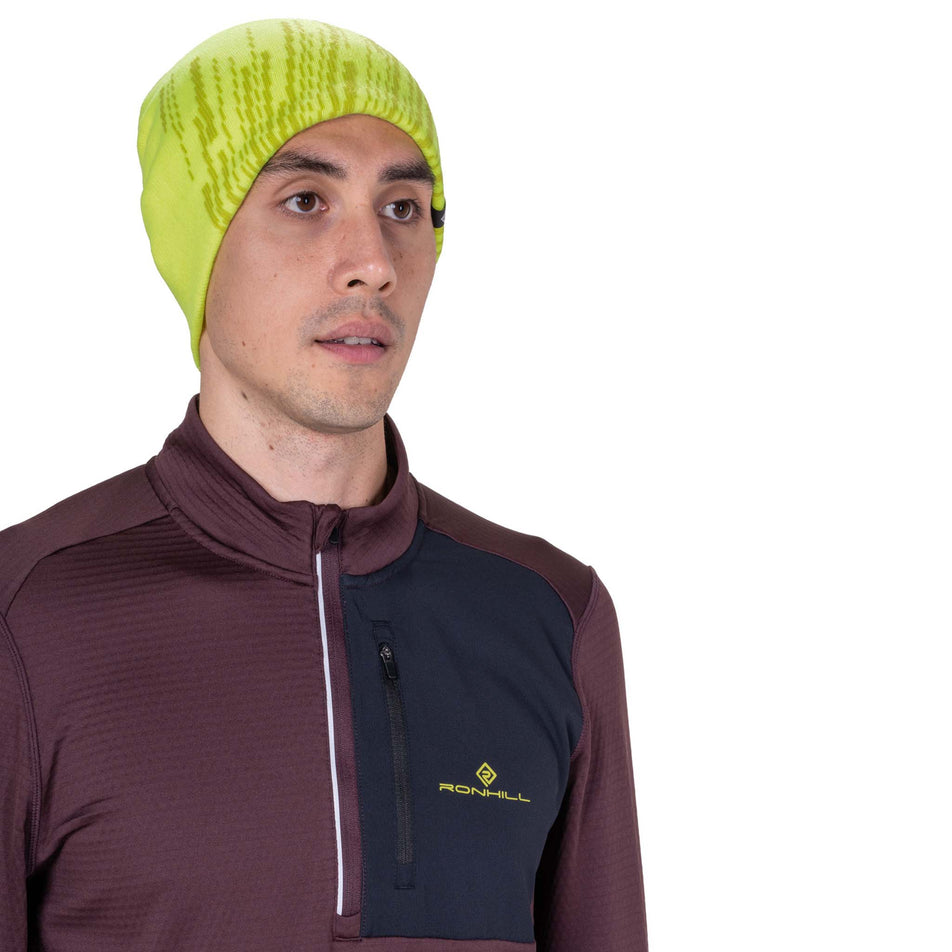 Front view of a model wearing the Ronhill Unisex Run Beanie in the Fluo Zest/Black colourway.