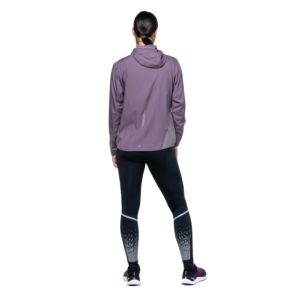 Back view of a model wearing the Ronhill Women's Tech Reflect Jacket in the Dark Iris/Reflect colourway. (8742187663522)