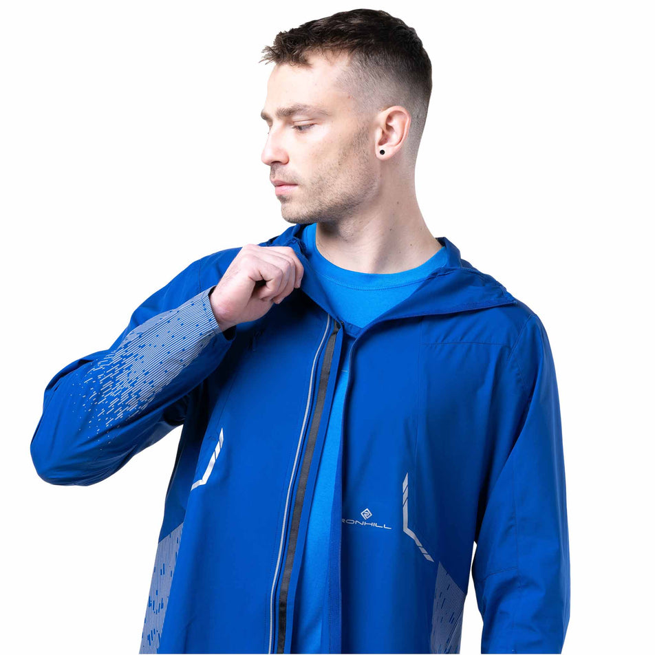 Front view of a model wearing the Ronhill Men's Tech Reflect Jacket in the Ocean/Reflect colourway. (8747618762914)