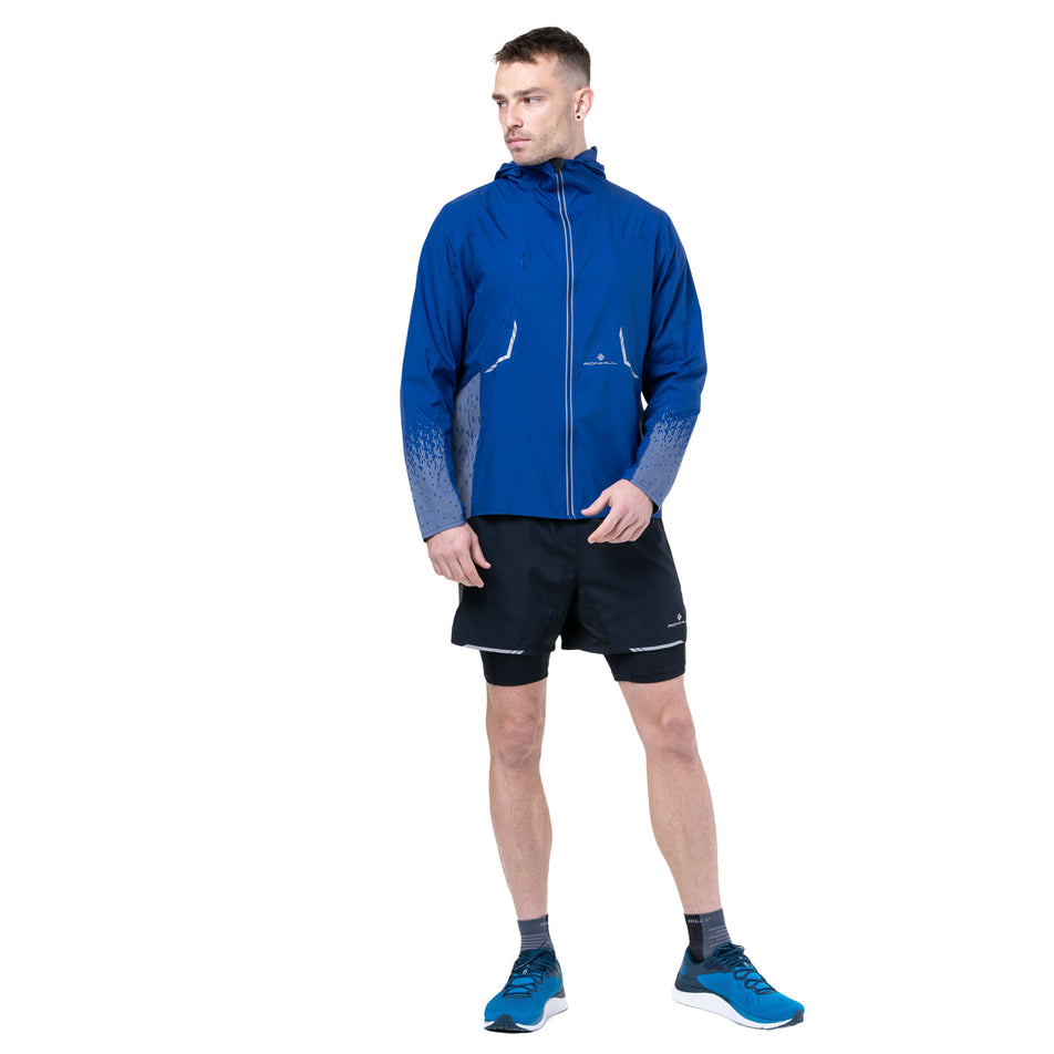 Front view of a model wearing the Ronhill Men's Tech Reflect Jacket in the Ocean/Reflect colourway. (8747618762914)