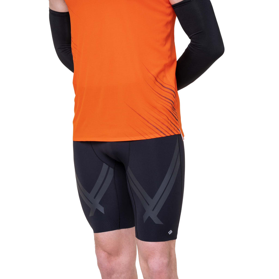 Front view of a model wearing the Ronhill Men's Tech Race Half Tight in the All Black colourway.