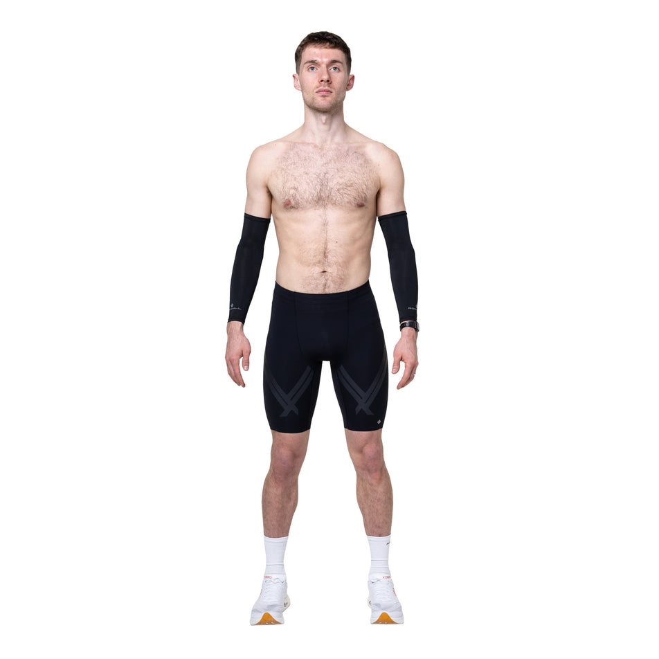 Front view of a model wearing the Ronhill Men's Tech Race Half Tight in the All Black colourway.