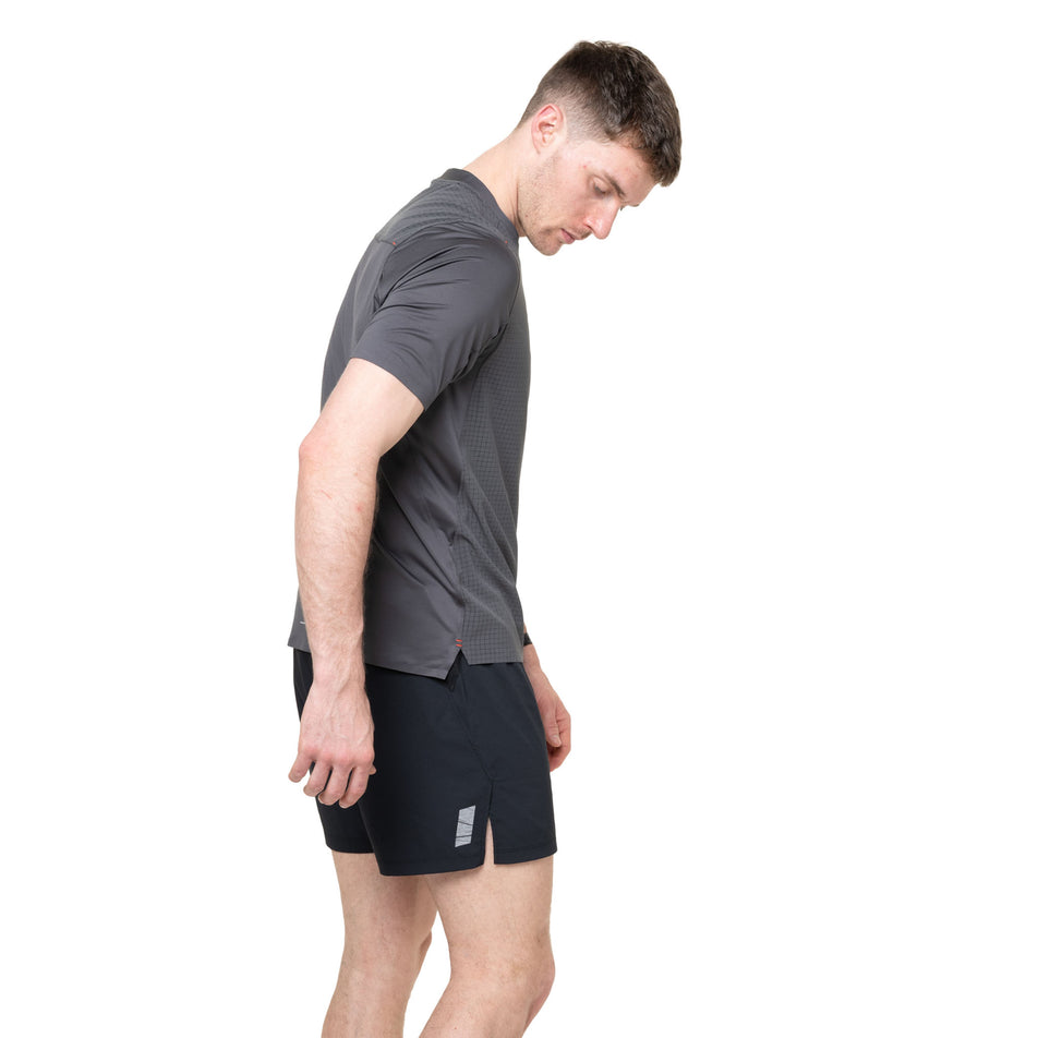 Side view of a model wearing the Ronhill Men's Tech All-Terrain S/S Tee in the Oxide colourway.