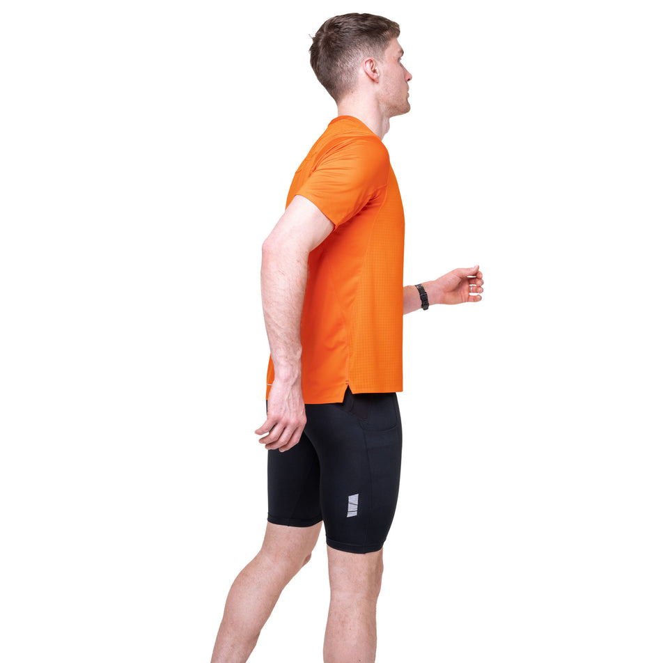 Side view of a model wearing the Ronhill Men's Tech All-Terrain S/S Tee in the Ronhill Red colourway.