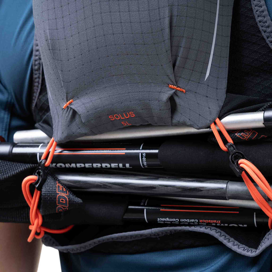 Running poles stored in the Ronhill Unisex Solus 5L in the Black/Ronhill Red colourway.