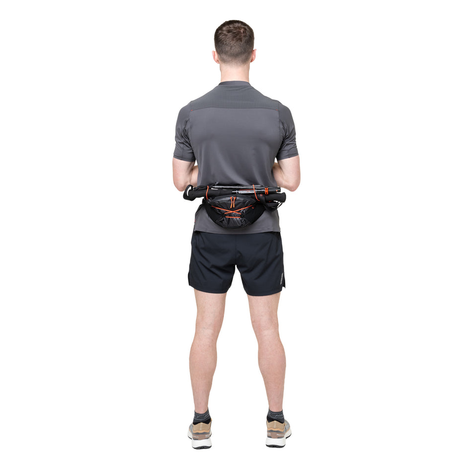 Running poles stored in the Ronhill Unisex Speed 180 in the Black/Ronhill Red colourway.