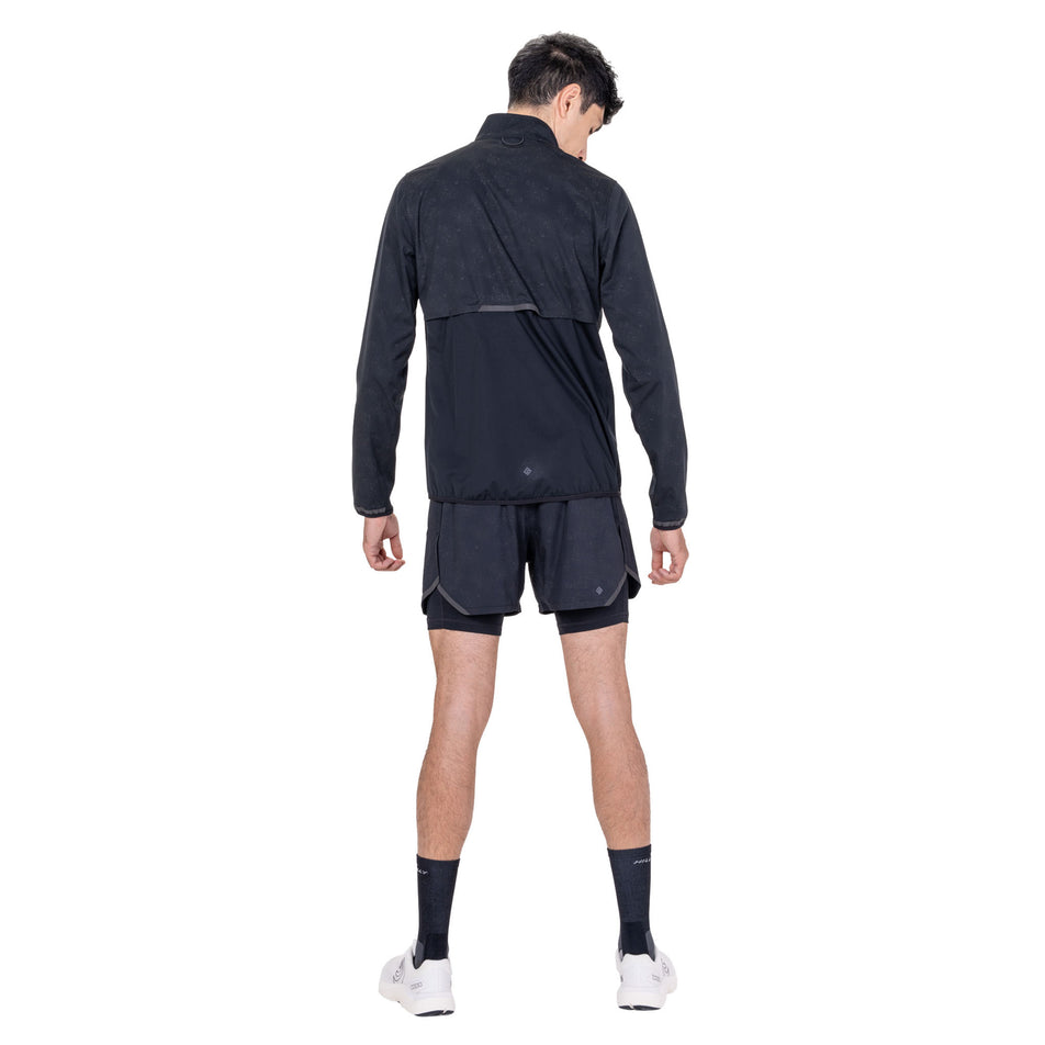 Back view of a model wearing the Ronhill Men's Tech Reflect Lux Jacket in the Black/Reflect colourway.