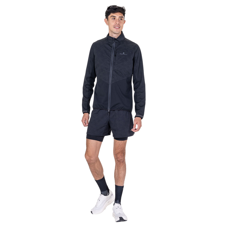 Front view of a model wearing the Ronhill Men's Tech Reflect Lux Jacket in the Black/Reflect colourway.