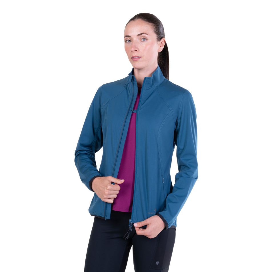 A model demonstrating the chest clip on the Ronhill Women's Tech Wind-Block Jacket in the Legion Blue colourway.