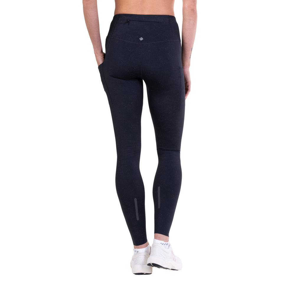 Back view of a model wearing the Ronhill Women's Tech Reflect Lux Tight in the Black/Reflect colourway.