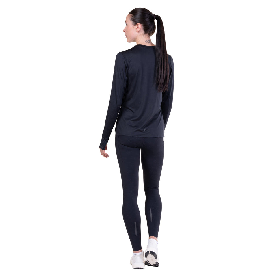 Back view of a model wearing the Ronhill Women's Tech Reflect Lux L/S Tee in the Black/Reflect colourway.
