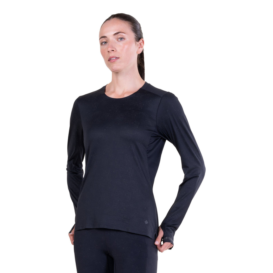 Front view of a model wearing the Ronhill Women's Tech Reflect Lux L/S Tee in the Black/Reflect colourway.