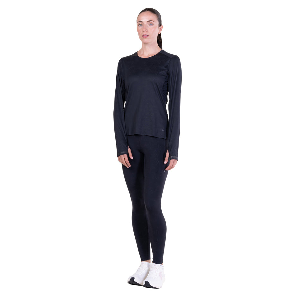 Front view of a model wearing the Ronhill Women's Tech Reflect Lux L/S Tee in the Black/Reflect colourway.