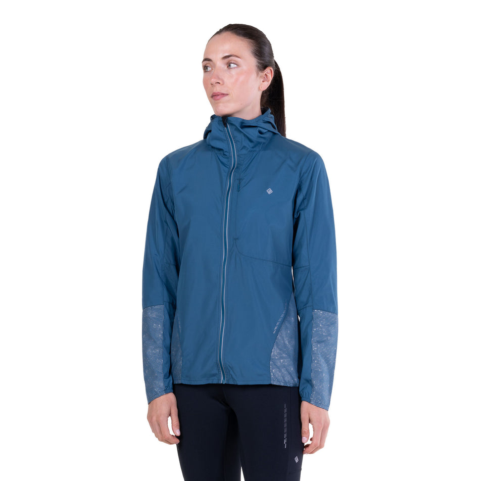 Front view of a model wearing the Ronhill Women's Tech Reflect Jacket in the Legion Blue/Reflect colourway.