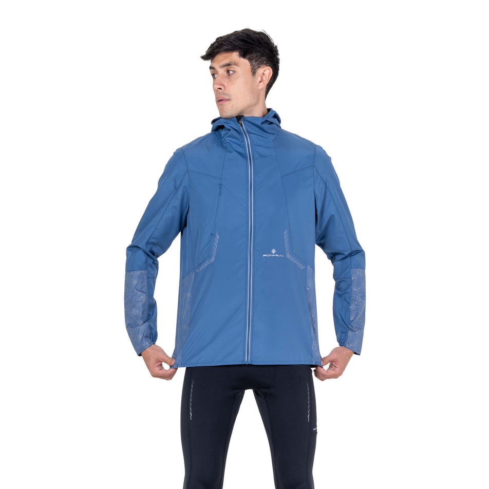 Front view of a model wearing the Ronhill Men's Tech Reflect Jacket in the Glacier/Reflect colourway.