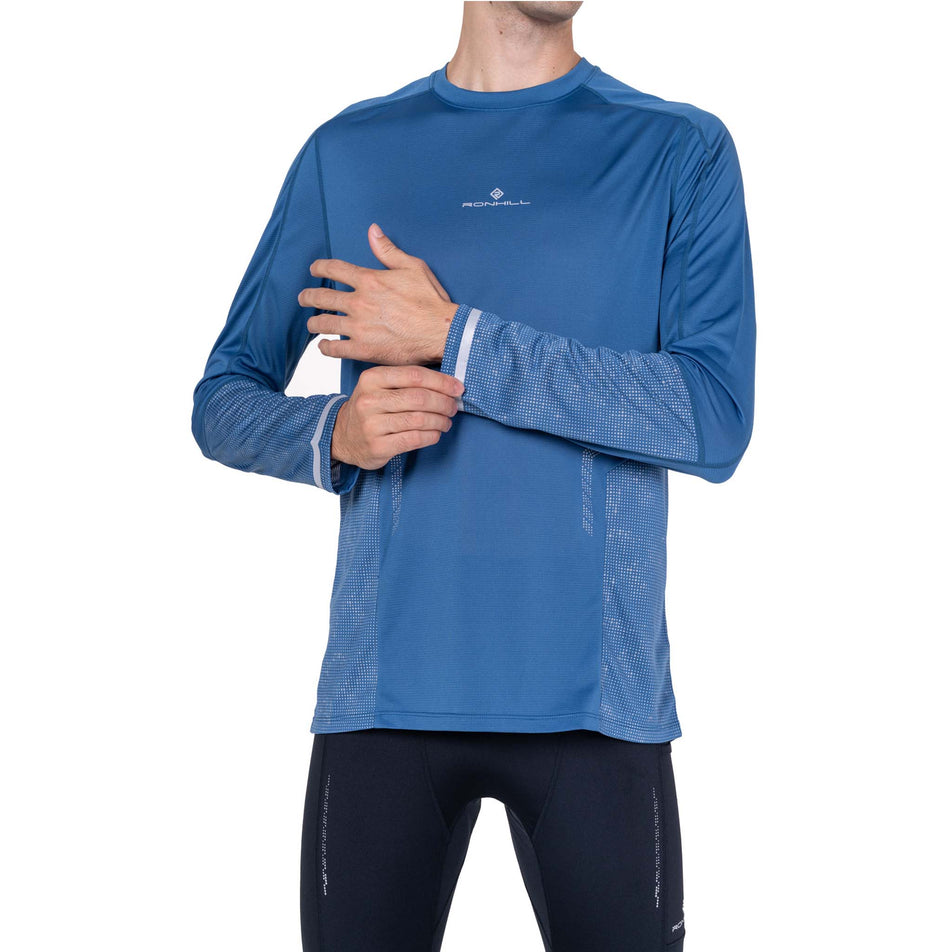 Front view of a model wearing the Ronhill Men's Tech Reflect L/S Tee in the Glacier/Reflect colourway.