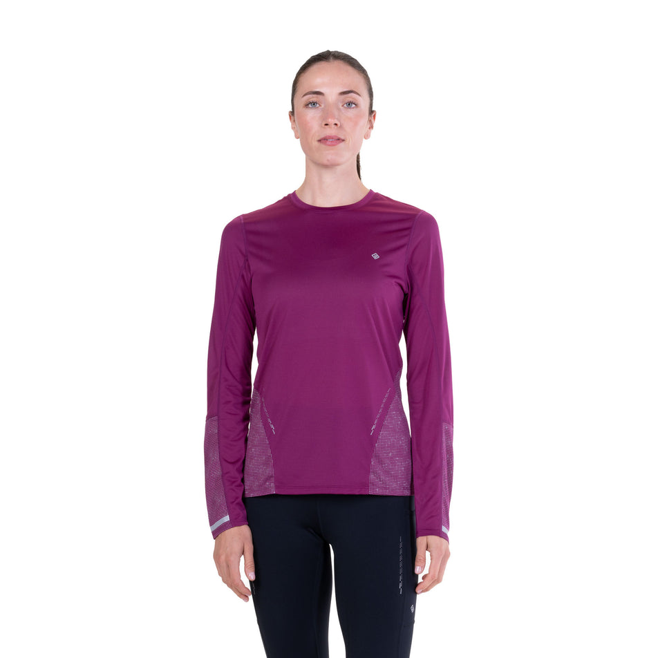 Front view of a model wearing the Ronhill Women's Tech Reflect L/S Tee in the Blackcurrant/Reflect colourway.