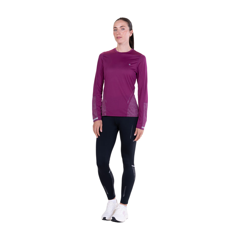 Front view of a model wearing the Ronhill Women's Tech Reflect L/S Tee in the Blackcurrant/Reflect colourway.