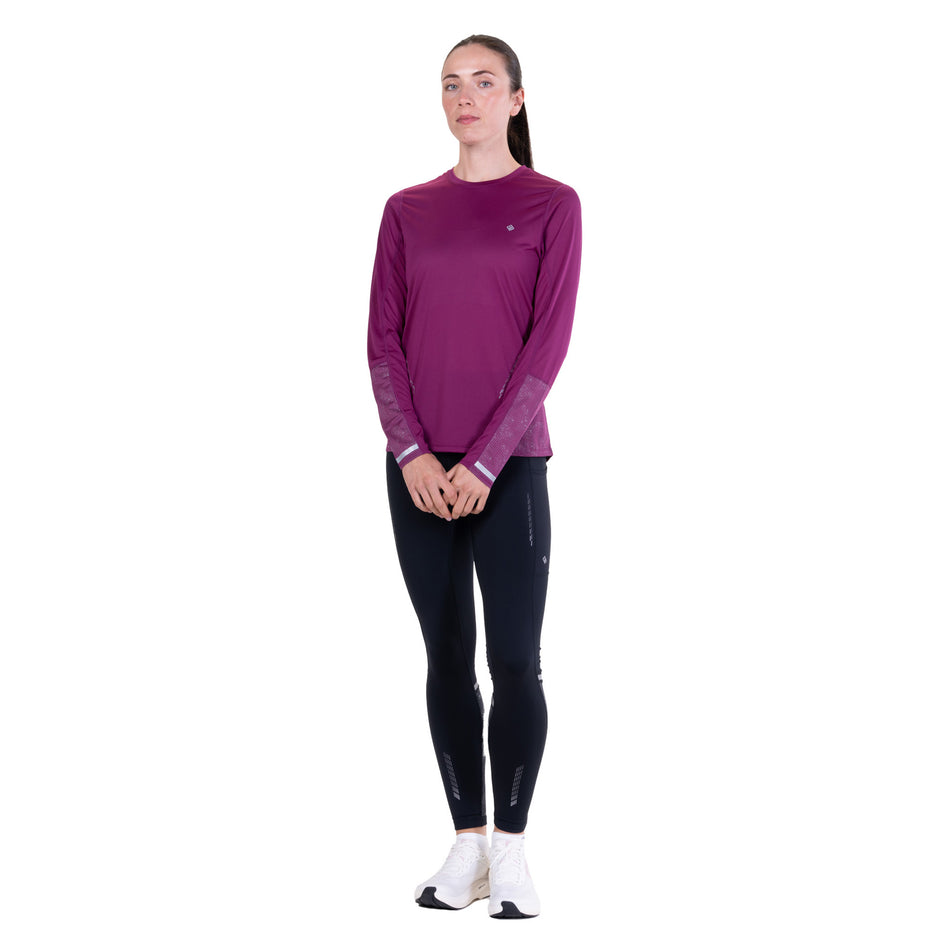 Front view of a model wearing the Ronhill Women's Tech Reflect L/S Tee in the Blackcurrant/Reflect colourway.