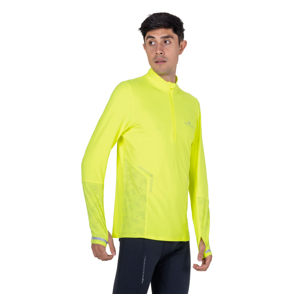 Front view of a model wearing the Ronhill Men's Tech Reflect 1/2 Zip in the Fluo Zest/Reflect colourway.
