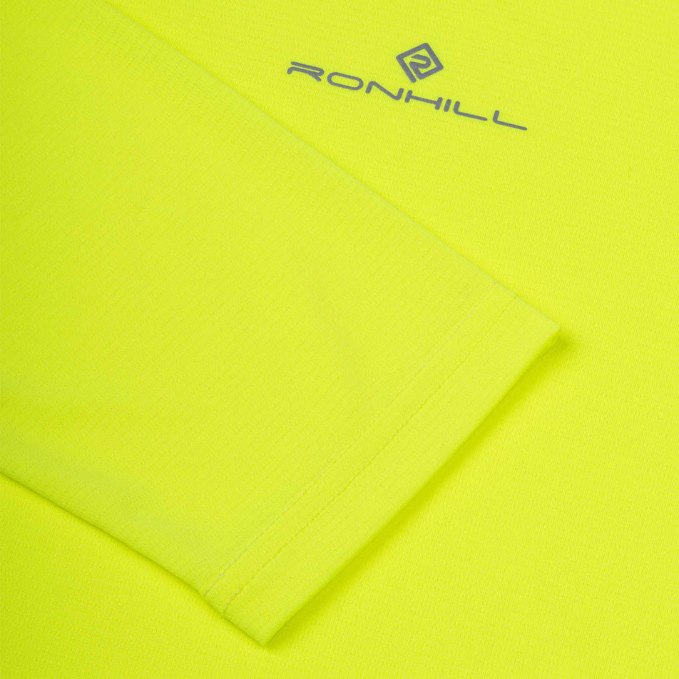 Close-up view of the Ronhill logo on the Ronhill Men's Core L/S Tee in the Fluo Zest colourway.