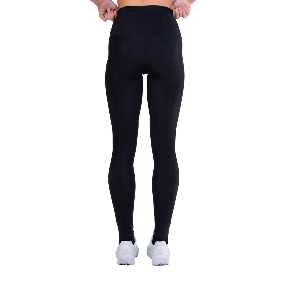 Back view of a model wearing the Ronhill Women's Tech Wind-Block Tight in the All Black colourway.