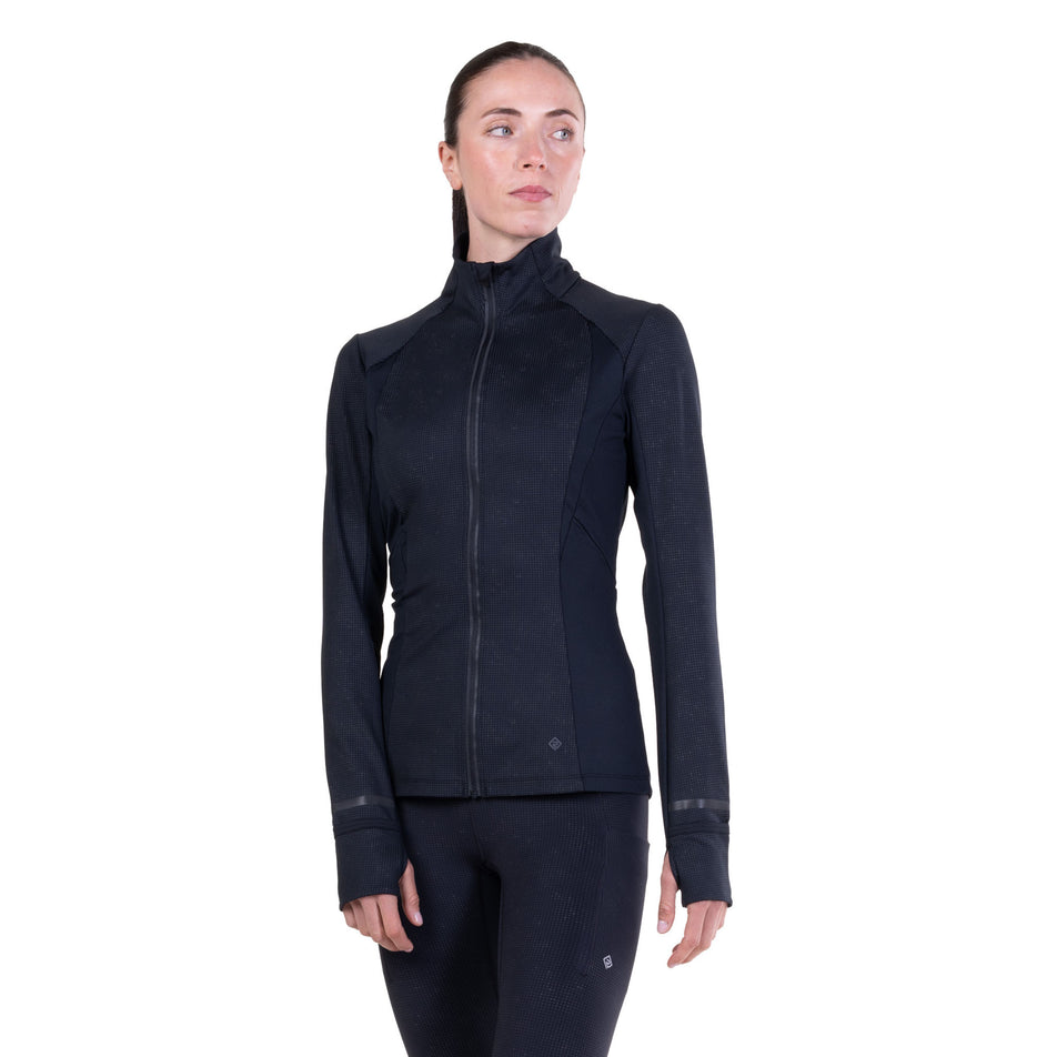 Front view of a model wearing the Ronhill Women's Tech Reflect Lux Jacket in the Black/Reflect colourway.