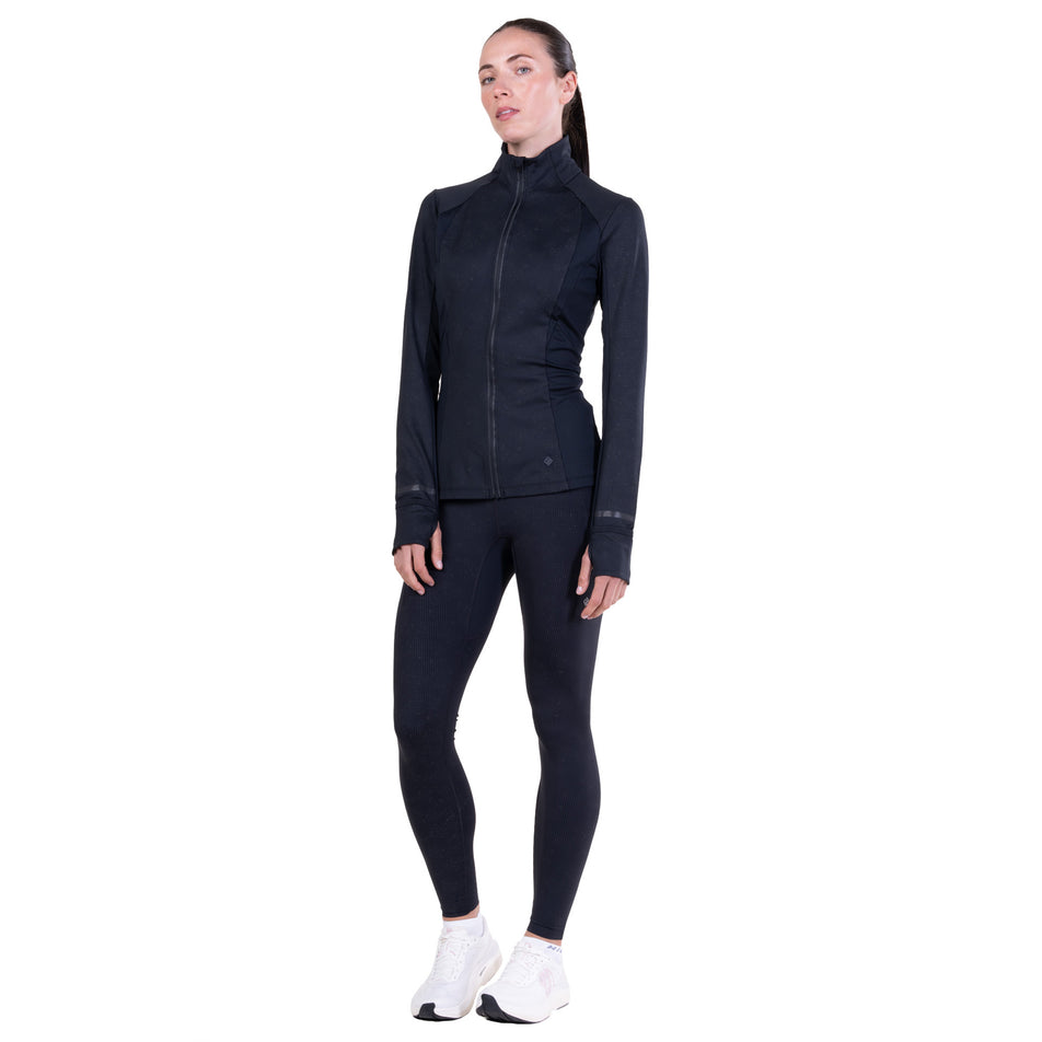 Front view of a model wearing the Ronhill Women's Tech Reflect Lux Jacket in the Black/Reflect colourway.