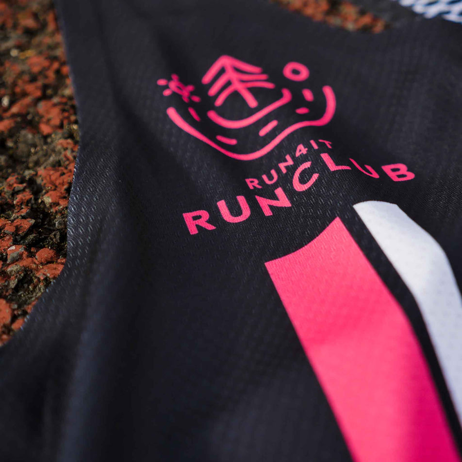 Close-up of the Pressio logo and Run4It Run Club logo on the front of the Pressio Run4It Run Club Women's Elite Singlet. (8489118728354)