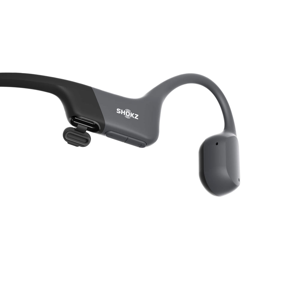 Close-up of the right earbud from a pair of Shokz Unisex OpenRun Mini Wireless Bone Conduction Headphones in the Black colourway. The USB-Type C charging port is visible in the image. (8541479305378)