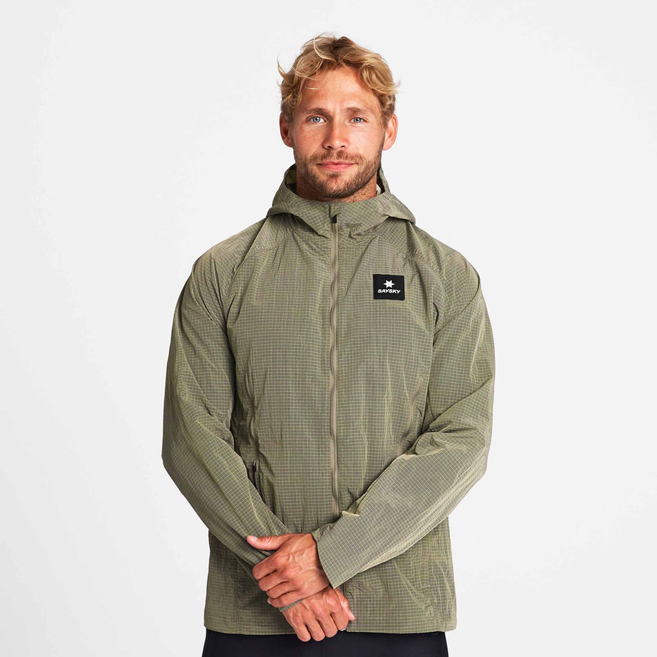Front view of a model wearing the SAYSKY Men's Clean Pace Shield Jacket in the Beige colourway.