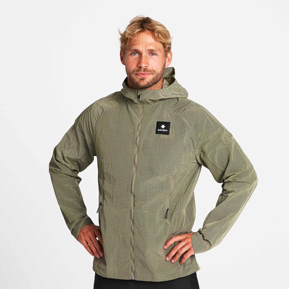 Front view of a model wearing the SAYSKY Men's Clean Pace Shield Jacket in the Beige colourway.