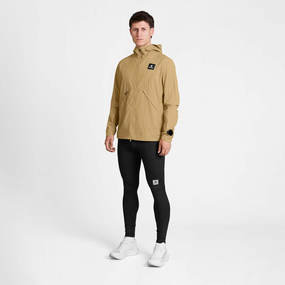 Front view of a model wearing the SAYSKY Men's Pace Tech Jacket in the Beige colourway.