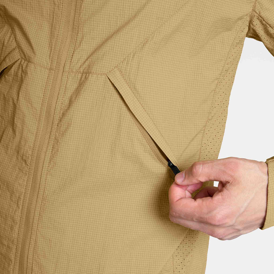 The zip pocket on the SAYSKY Men's Pace Tech Jacket in the Beige colourway.