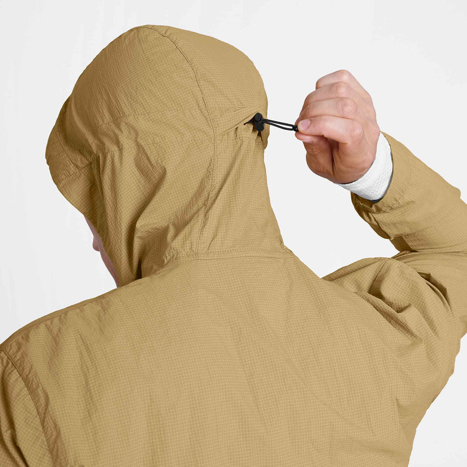The adjustable hood toggle the SAYSKY Men's Pace Tech Jacket in the Beige colourway.
