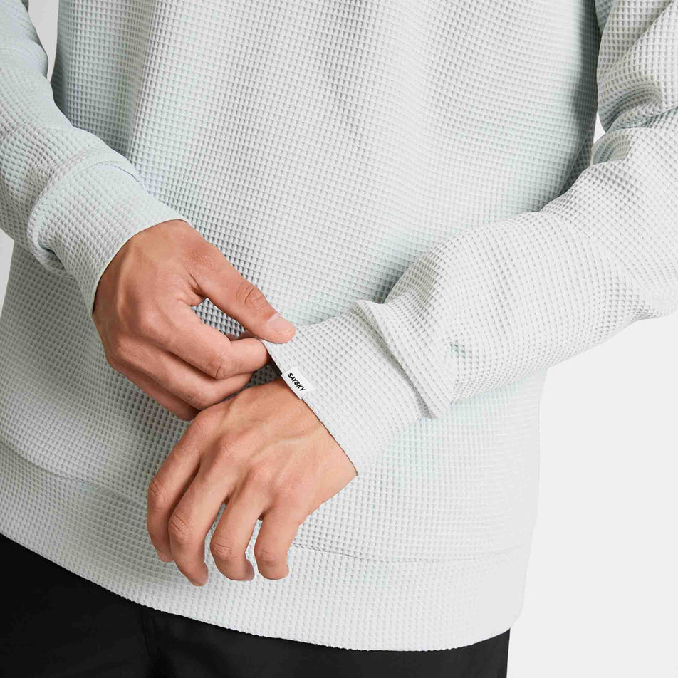 Close-up view of the SAYSKY label on the sleeve cuff of the SAYSKY Men's Motion Waffle Long Sleeve in the Grey colourway.