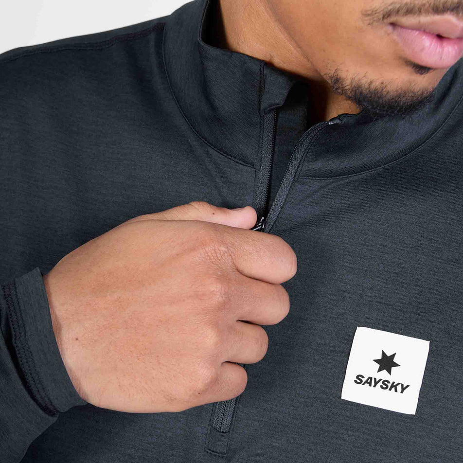 Front view of a model wearing the SAYSKY Men's Pace Half Zip Long Sleeve in the Black colourway.