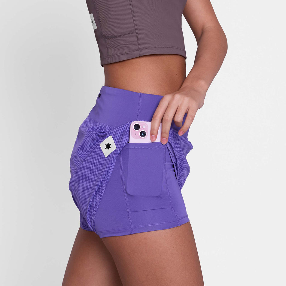 A model demonstrating the stash pocket on the side of the SAYSKY Women's Zig Zag Pace Shorts 3