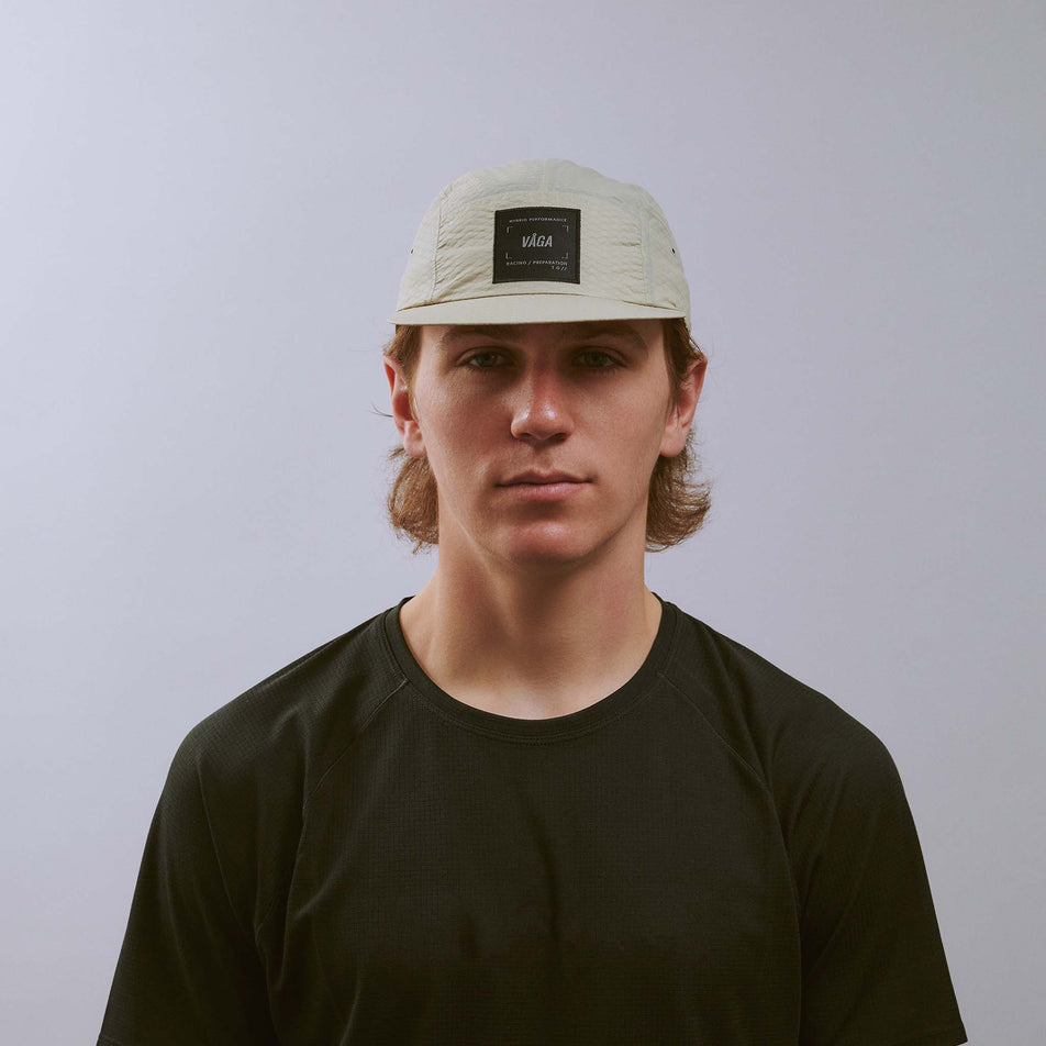 Front view of a model wearing the VÅGA Unisex Viper Lite Cap in the Taupe colourway.