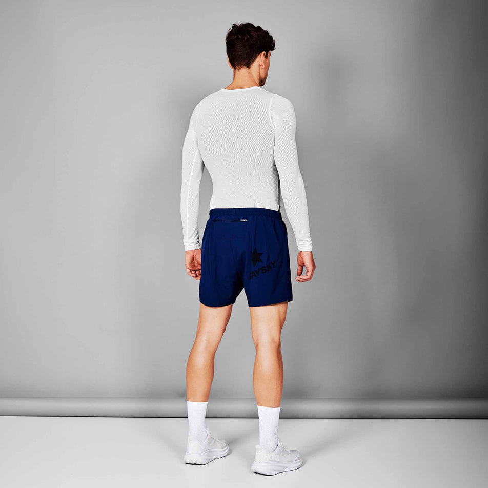 Back view of a model wearing the SAYSKY Unisex Mesh Base Layer Long Sleeve in the White colourway. Model is also wearing shorts, socks and shoes. (8601308266658)