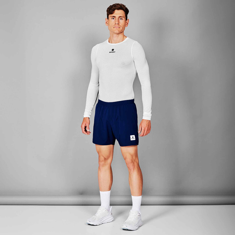 Front view of a model wearing the SAYSKY Unisex Mesh Base Layer Long Sleeve in the White colourway. Model is also wearing shorts, socks and shoes. (8601308266658)